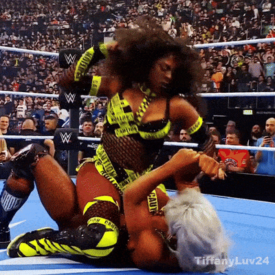 two women are wrestling in a ring and one of them is wearing a caution tape outfit