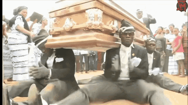 a group of men are carrying a wooden coffin with a sign that says ' r.i.p ' on it