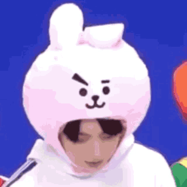 a person wearing a pink bunny hat with an angry face .