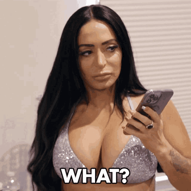 a woman in a bikini is holding a cell phone and says " what "