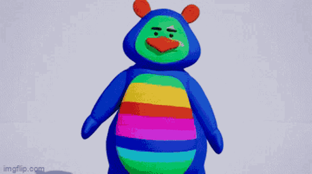 a blue teddy bear with a rainbow colored belly is standing in front of a white background