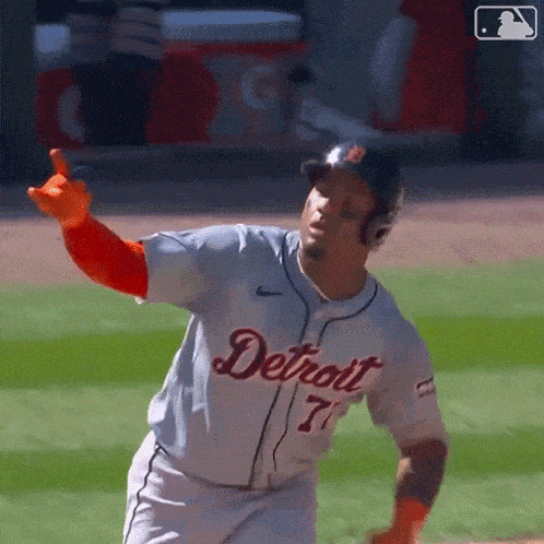 a baseball player for the detroit tigers is running on a field .