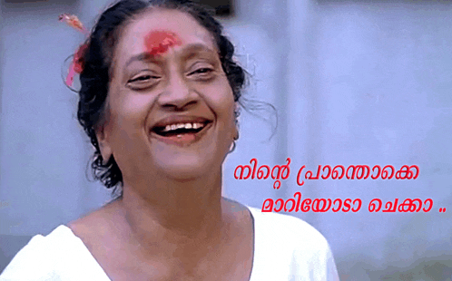 a woman with a red flower on her forehead is smiling with a caption in a foreign language below her