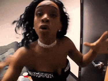 a woman wearing a choker and a strapless dress is making a face