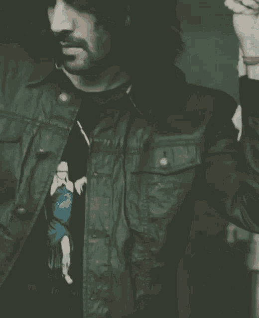 a man wearing a black t-shirt and a black leather jacket