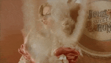 a woman in a pink dress is standing in front of a mirror and looking at herself .