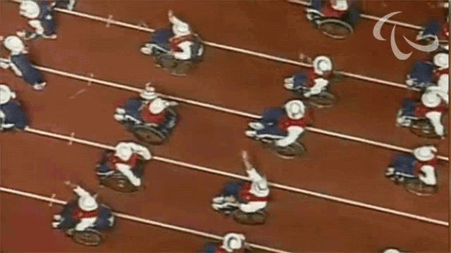 people in wheelchairs are racing on a track