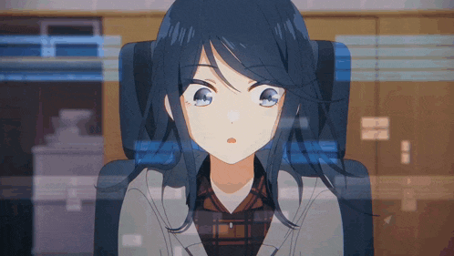 a girl with long blue hair is sitting in front of a computer screen