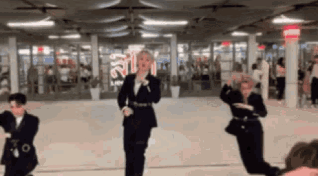 a group of people in suits are dancing in a room with a sign that says ' a ' on it