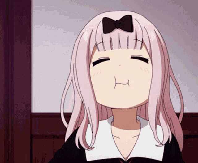 a girl with pink hair and a bow on her head makes a funny face