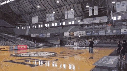 a man stands on a basketball court in front of a sign that says bwin