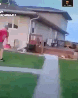 a person is walking down a sidewalk next to a house .