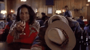 a man and a woman are sitting at a table drinking wine .