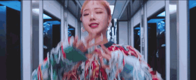 a woman is dancing in a hallway wearing a colorful sweater .