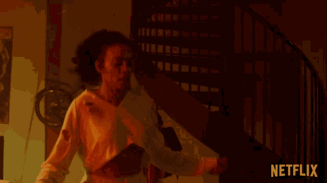 a woman in a white crop top is dancing in front of a spiral staircase with netflix written on the bottom