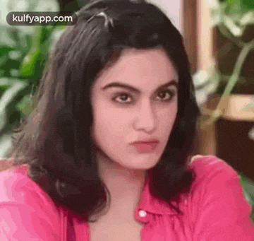 a close up of a woman 's face with a pink shirt on .