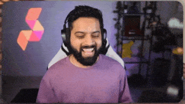 a man with a beard wearing headphones and a purple shirt .