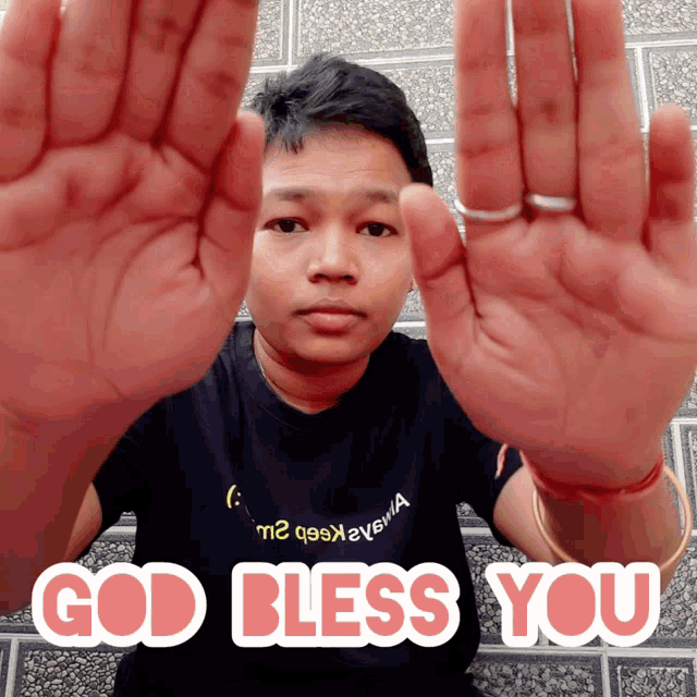 a man wearing a black shirt that says god bless you on it