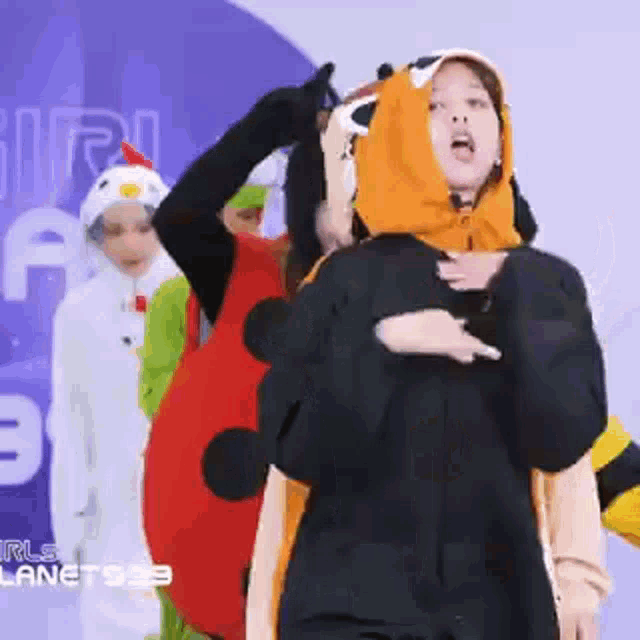 a group of children are dressed up in costumes and dancing .