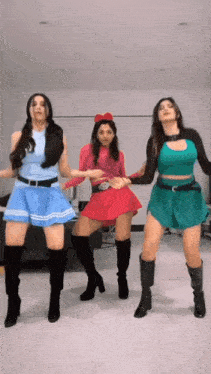 a group of three women are dancing together in a living room .