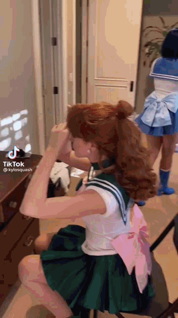 a woman in a sailor suit is sitting in front of a mirror .