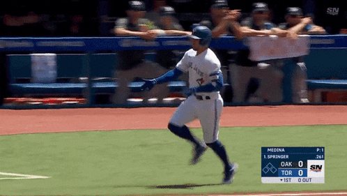 a blue jays baseball player is running towards the dugout