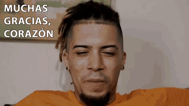 a man with dreadlocks is smiling with the words muchas gracias corazon below him