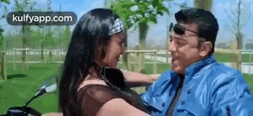 a man and a woman are sitting on a motorcycle .