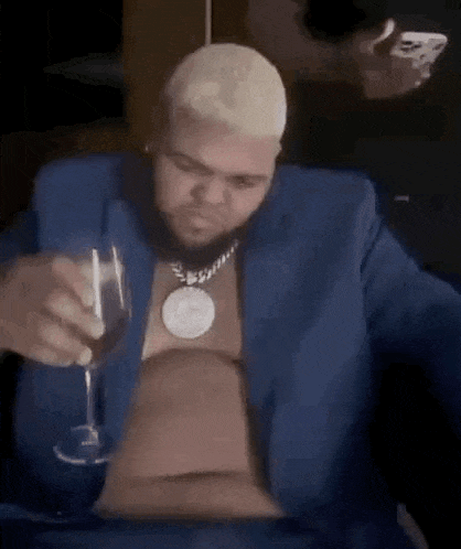 a man in a blue suit is holding a wine glass .