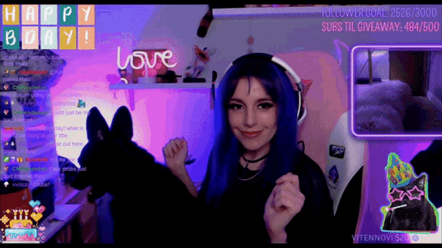 a girl with blue hair is dancing in front of a screen that says happy day