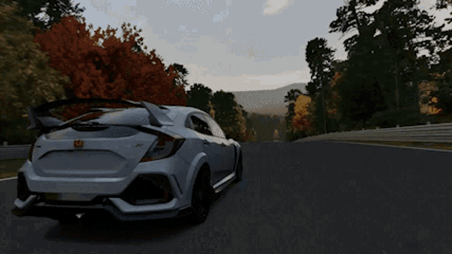 a white honda civic type r driving down a road