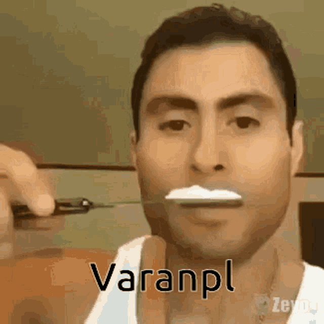 a man is holding a knife in his mouth with a spoon in his mouth .