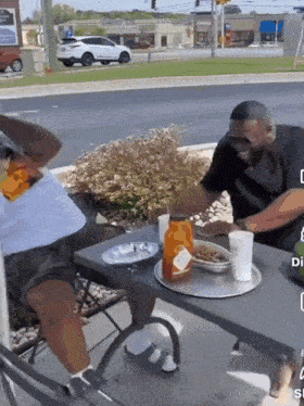a man is sitting at a table with a tray of food on it