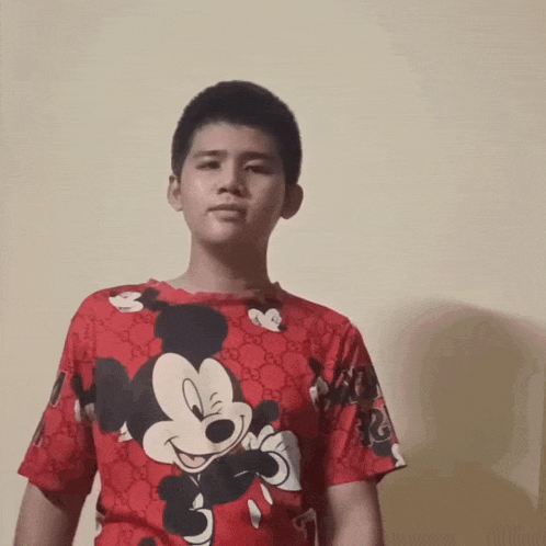 a young boy with short hair is making a funny face .