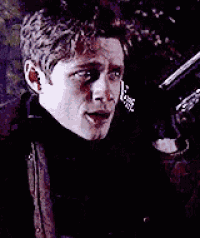 a man is holding a gun in his hand in a dark room .