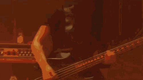a person playing a guitar in front of a fire