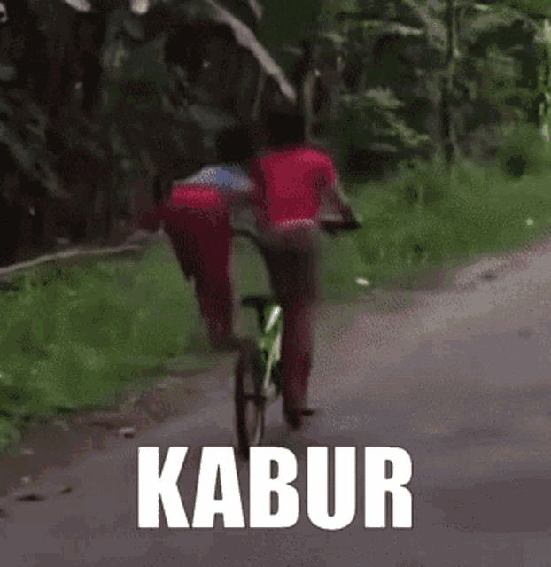two people are riding bicycles down a road with the word kabur written on the bottom