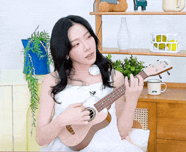 a woman in a white dress is playing a guitar with a yamaha logo on it