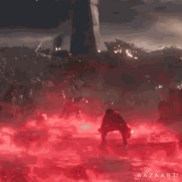a person is standing in the middle of a red smoke filled area .