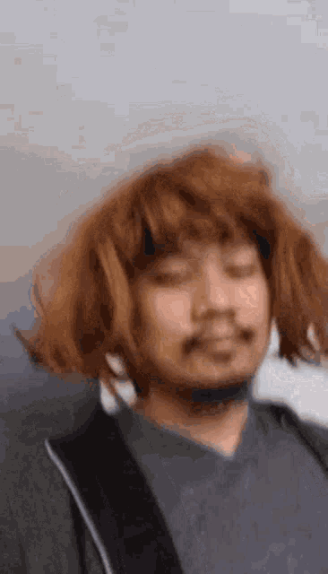 a man wearing a wig and a beard is making a funny face with his eyes closed .