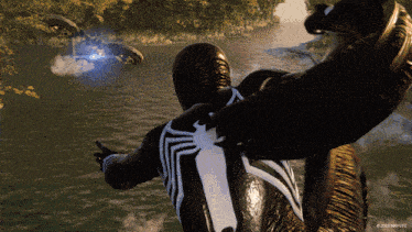 a man in a black and white spiderman suit is flying over a body of water