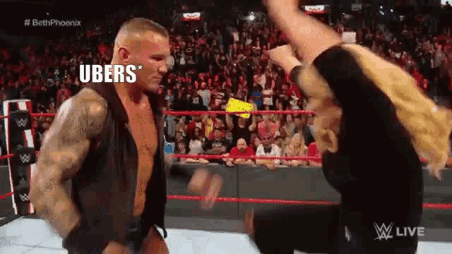 a man and a woman are fighting in a wrestling ring . the man is wearing a black vest .
