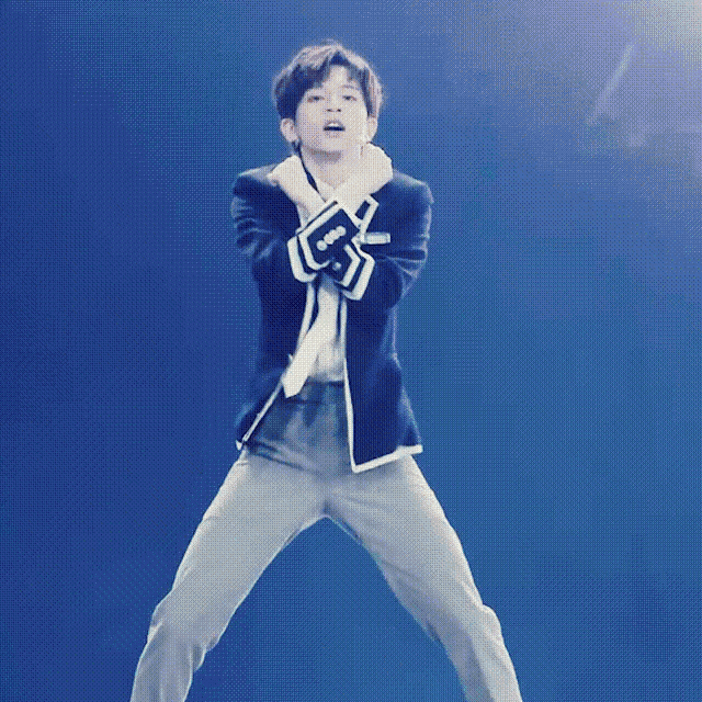 a man in a suit is dancing on a stage