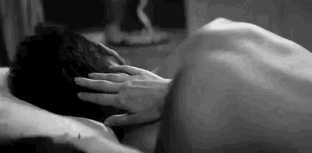 a black and white photo of a man and a woman having sex .