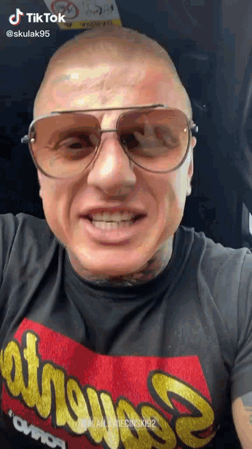 a man wearing sunglasses and a t-shirt that says " aviator "