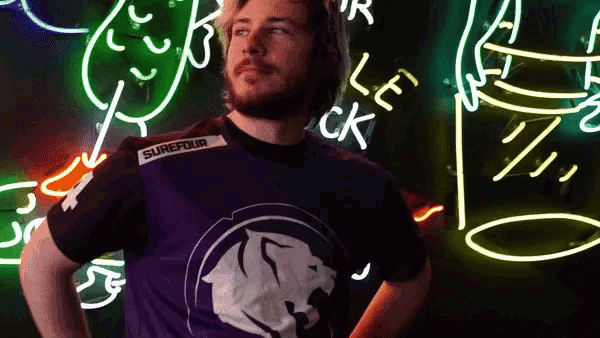 a man wearing a purple shirt with the word surefour on it