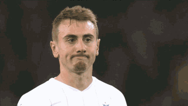 a man wearing a white shirt with a blue star on the front