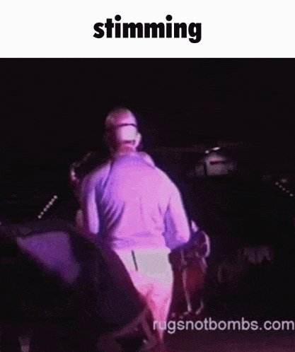 a man in a purple shirt is standing in front of a crowd with the word stunning above him