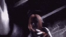 a close up of a person holding a sword in their hand in a dark room .
