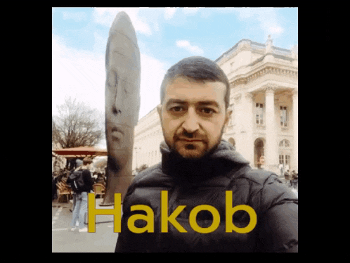 a man standing in front of a statue with the name hakob written on the bottom